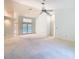 Bright living room featuring multiple ceiling fans, French doors, and a chandelier to create a light atmosphere at 2725 Onizuka Ct, Palm Harbor, FL 34683