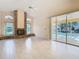 Bright and spacious living room featuring tile flooring, a fireplace, and sliding glass doors to the lanai at 2725 Onizuka Ct, Palm Harbor, FL 34683