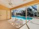 Covered patio overlooking a clear blue swimming pool surrounded by screened enclosure at 2725 Onizuka Ct, Palm Harbor, FL 34683