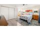 Inviting bedroom with a ceiling fan, neutral walls, stylish bedding, and a view into the bathroom at 2757 Countryside Blvd # 103, Clearwater, FL 33761