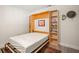 Flex room with open wall bed featuring gray wood floors and built in shelves at 2757 Countryside Blvd # 103, Clearwater, FL 33761