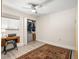 Bedroom with grey wood floors, a ceiling fan, a vintage sewing table and an organized closet at 2757 Countryside Blvd # 103, Clearwater, FL 33761