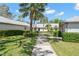 Manicured landscaping and mature trees along a sidewalk to a property, enhancing the community's aesthetic appeal at 2757 Countryside Blvd # 103, Clearwater, FL 33761
