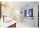 Bright bathroom with double sinks, seamless glass shower, and a soaking tub with a window at 3013 Ridgevale Cir, Valrico, FL 33596