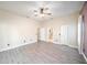 Bedroom with a ceiling fan, light gray wood flooring and multiple entry doors at 3013 Ridgevale Cir, Valrico, FL 33596