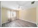 Bedroom features gray wood flooring, neutral paint, and a ceiling fan with lighting at 3013 Ridgevale Cir, Valrico, FL 33596