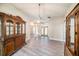 Dining room featuring gray wood flooring, elegant light fixture, and decorative wooden cabinets at 3013 Ridgevale Cir, Valrico, FL 33596