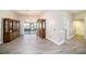 Open dining room features gray wood flooring, elegant light fixture, and access to screened porch at 3013 Ridgevale Cir, Valrico, FL 33596