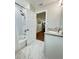 Beautiful bathroom with a shower, granite-topped vanity, and tiled floors extending to the entryway at 3623 N 53Rd St, Tampa, FL 33619