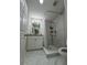 This bathroom features marble floors, a shower with gray tile surround, and a white vanity at 3623 N 53Rd St, Tampa, FL 33619