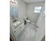 Clean bathroom featuring white vanity, marble floors, toilet, and shower with white tiling at 3623 N 53Rd St, Tampa, FL 33619