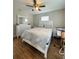Bedroom with a large bed, wood floor, ceiling fan, dresser, and a nightstand at 3623 N 53Rd St, Tampa, FL 33619