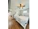 Bedroom with a large bed, wood floor, ceiling fan, dresser, and a nightstand with ensuite bath access at 3623 N 53Rd St, Tampa, FL 33619