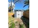 Modern backyard shed featuring double doors and storage, complemented by a privacy fence at 3623 N 53Rd St, Tampa, FL 33619