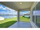 Back porch overlooking the lake, lawn, and blue sky with fluffy white clouds at 38255 Sonnet Landing Ave, Zephyrhills, FL 33540