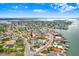 Aerial view showcasing neighborhood with waterfront access, mature trees, and residential homes at 411 Virginia Ave, Madeira Beach, FL 33708