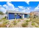 Back exterior of a blue house with a pergola, patio area, and well-maintained landscaping at 411 Virginia Ave, Madeira Beach, FL 33708