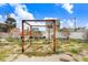 Backyard with a wooden pergola, outdoor seating area, and lush landscaping under a bright blue sky at 411 Virginia Ave, Madeira Beach, FL 33708