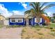 Charming single-story blue home with a brick driveway, palm tree, and well-lit exterior on a sunny day at 411 Virginia Ave, Madeira Beach, FL 33708