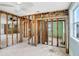 Partially renovated open living room with exposed framing, new electric, and view to another room at 411 Virginia Ave, Madeira Beach, FL 33708