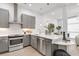 Modern kitchen featuring stainless steel appliances, grey cabinets, and white subway tile backsplash at 4156 Gauge Line Loop, Tampa, FL 33624