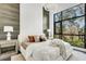 Bright main bedroom boasts a unique accent wall, plush bedding, and a large window with a scenic view at 4156 Gauge Line Loop, Tampa, FL 33624