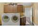 Functional laundry room with wooden cabinets, sink, and modern washer and dryer units at 450 Knights Run Ave # 1704, Tampa, FL 33602