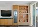 Living room featuring custom built-in shelving, a wine fridge, and access to a balcony at 450 Knights Run Ave # 1704, Tampa, FL 33602