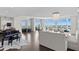 Bright, spacious living room with modern chandelier, piano, and panoramic water views at 450 Knights Run Ave # 1704, Tampa, FL 33602
