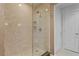 Tiled walk-in shower with glass door and shower head in neutral colors at 450 Knights Run Ave # 1704, Tampa, FL 33602