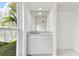 Bright wet bar featuring a mirror, storage cabinets, and a window with a backyard view at 4735 Foxshire Cir, Tampa, FL 33624