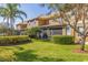 Townhome featuring a well-maintained backyard with lush grass, screened lanai, and verdant landscaping at 4739 Silverking Way, Palm Harbor, FL 34684