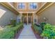 Charming townhome entrance with well-manicured hedges lining the walkway to the front door at 4739 Silverking Way, Palm Harbor, FL 34684