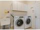 Laundry room includes washer, dryer, utility sink, and white cabinets for storage at 4739 Silverking Way, Palm Harbor, FL 34684
