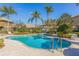 Community pool oasis surrounded by lush greenery, palm trees, and comfortable lounge seating at 4739 Silverking Way, Palm Harbor, FL 34684