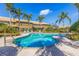 Community pool area featuring lush landscaping, swaying palms, and inviting lounge chairs at 4739 Silverking Way, Palm Harbor, FL 34684