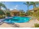 Community pool with inviting turquoise water, surrounded by manicured landscaping and palm trees at 4739 Silverking Way, Palm Harbor, FL 34684