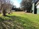 Spacious backyard and trees behind a white picket fence, with a parked truck near a home's exterior wall at 4951 John Wesley Pl, Plant City, FL 33567