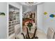 View of the dining room featuring glass table, view into the living room, and view to kitchen in this beautiful home at 8155 Elisabeth Ln, Seminole, FL 33777