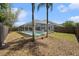 Wide shot of fenced backyard with screened-in pool, and established tropical landscaping at 8941 Southbay Dr, Tampa, FL 33615