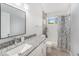 Bright bathroom features a granite countertop, modern sink, and shower with decorative curtain at 8941 Southbay Dr, Tampa, FL 33615