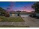 Charming single-Gathering home featuring a well-maintained lawn, driveway, and two-car garage under a lovely sky at 8941 Southbay Dr, Tampa, FL 33615