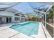 Sparkling blue pool with screened enclosure, surrounded by lounge chairs and a patio area at 8941 Southbay Dr, Tampa, FL 33615