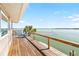 This home features a deck with stunning waterfront views, palm trees, and railing at 9696 Little Gasparilla Isand, Placida, FL 33946