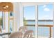 Bright dining room with a glass table, wicker chairs, waterfront views, and a woven light fixture at 9696 Little Gasparilla Isand, Placida, FL 33946
