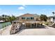 Exterior view of canal-front home with elevated deck and stairs at 9696 Little Gasparilla Isand, Placida, FL 33946