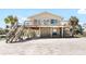 Charming elevated beach house featuring a spacious front deck, stairs, and beachfront access at 9696 Little Gasparilla Isand, Placida, FL 33946