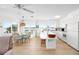 Open-concept kitchen and dining area with white cabinets, breakfast bar, and expansive water views at 9696 Little Gasparilla Isand, Placida, FL 33946