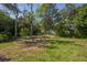 Beautiful, spacious backyard featuring an open lawn surrounded by lush, mature trees at 14472 Linden Dr, Spring Hill, FL 34609