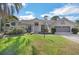 Charming single-story home features a well-manicured lawn, lush landscaping, and a two-car garage at 14472 Linden Dr, Spring Hill, FL 34609